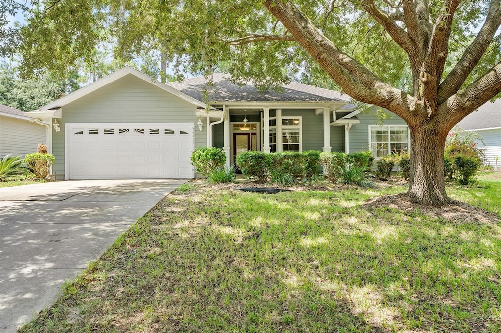 single story home with a front yard, concrete driveway, and an attached garage