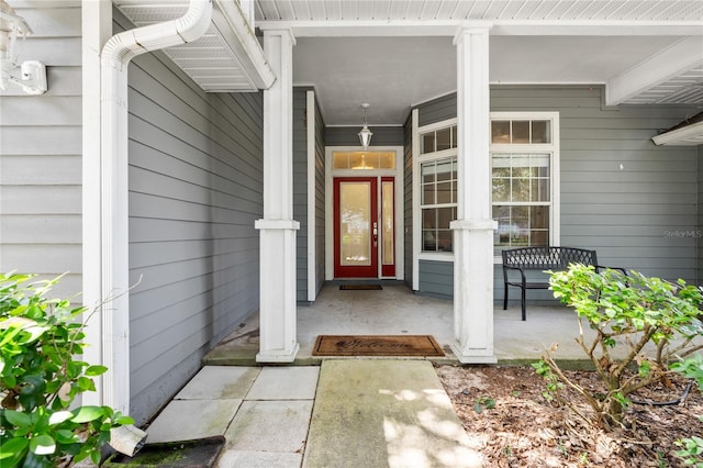 view of exterior entry featuring covered porch