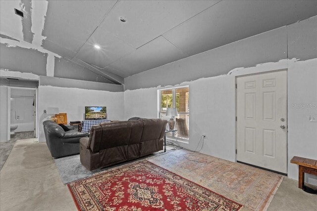 living room featuring carpet flooring and vaulted ceiling