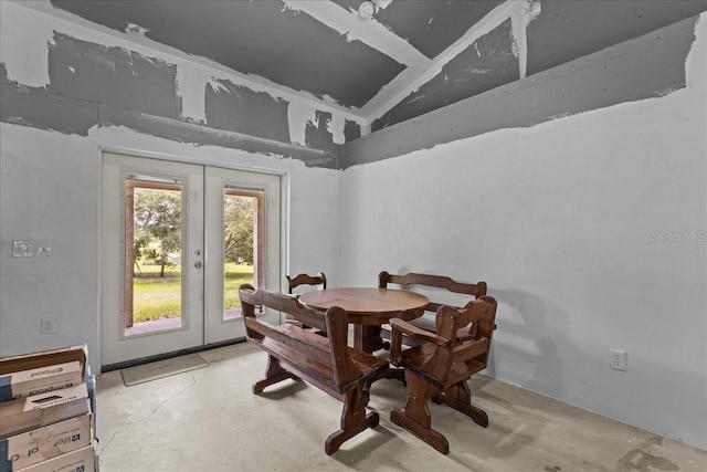 dining space featuring french doors and lofted ceiling