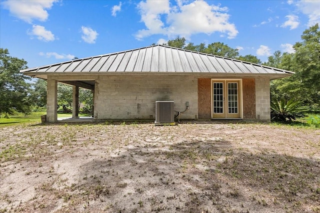 7340 NW 21st Ave, Bell, FL 32619 - back of house featuring central air condition unit, concrete block siding, a standing seam roof, french doors, and metal roof