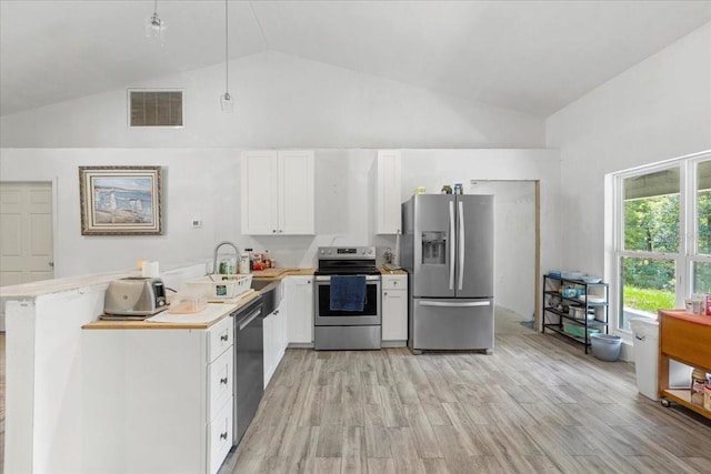 7340 NW 21st Ave, Bell, FL 32619 - kitchen with visible vents, appliances with stainless steel finishes, light countertops, high vaulted ceiling, and white cabinets
