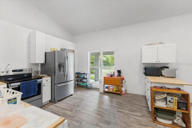 7340 NW 21st Ave, Bell, FL 32619 - kitchen with appliances with stainless steel finishes, vaulted ceiling, light countertops, white cabinets, and light wood finished floors