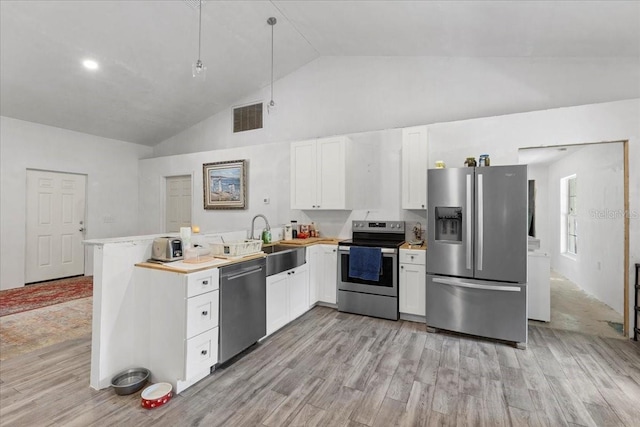 7340 NW 21st Ave, Bell, FL 32619 - kitchen with appliances with stainless steel finishes, a sink, a peninsula, white cabinetry, and visible vents