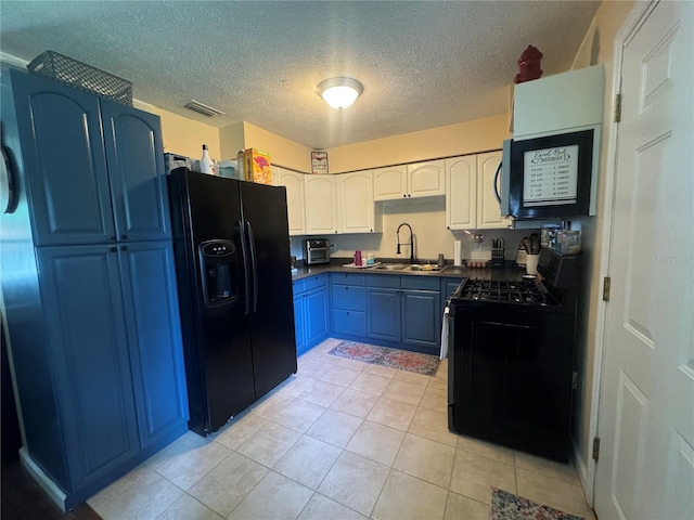 kitchen with sink, blue cabinetry, light tile patterned floors, and black appliances