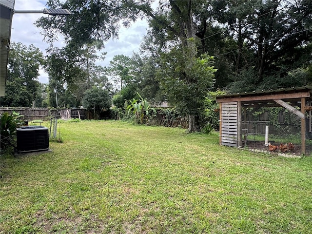 view of yard featuring cooling unit and an outbuilding