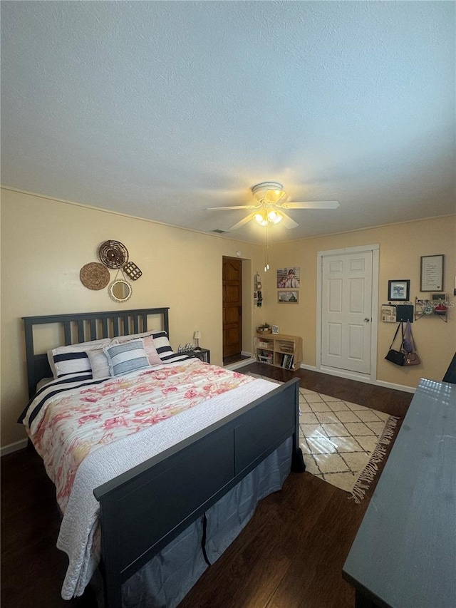 bedroom featuring hardwood / wood-style flooring, a textured ceiling, and ceiling fan