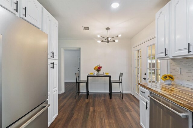 kitchen with white cabinetry, an inviting chandelier, french doors, dark hardwood / wood-style floors, and stainless steel appliances