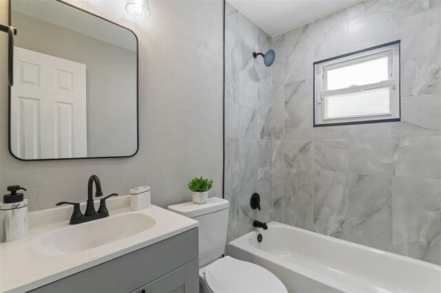 full bathroom featuring toilet, vanity, and tiled shower / bath