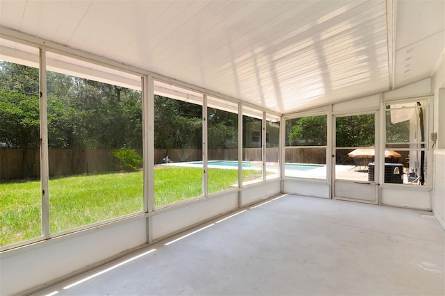 unfurnished sunroom featuring a wealth of natural light and vaulted ceiling