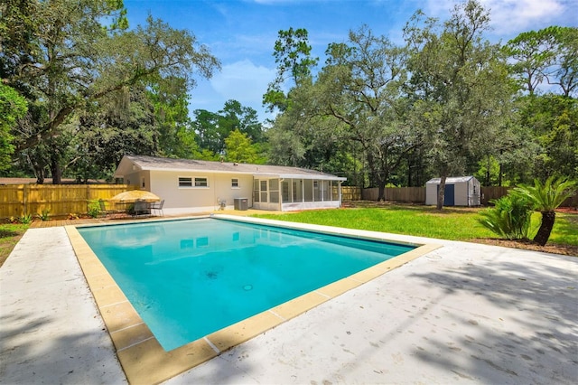 view of pool with a lawn, a storage shed, and a patio