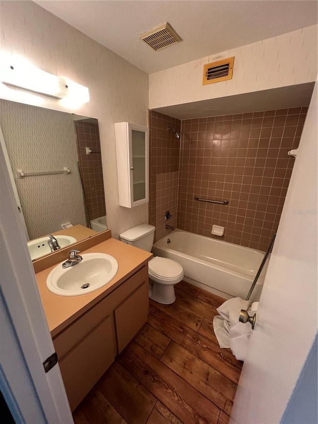 bathroom featuring visible vents, shower / bathing tub combination, wood finished floors, and vanity