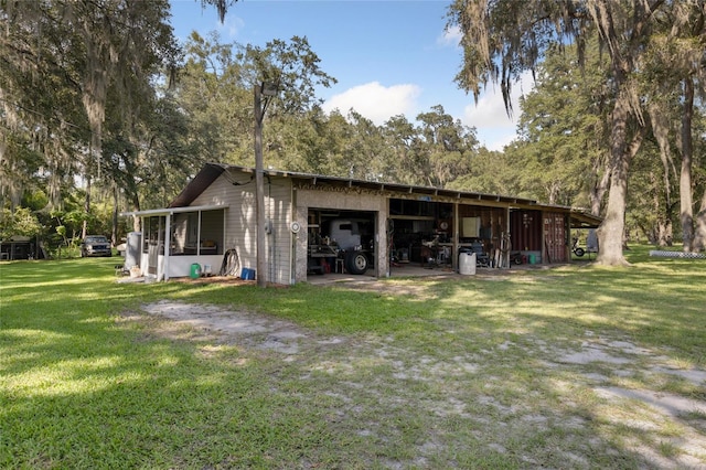 back of house with a lawn and a garage