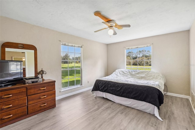 bedroom with ceiling fan and light hardwood / wood-style flooring