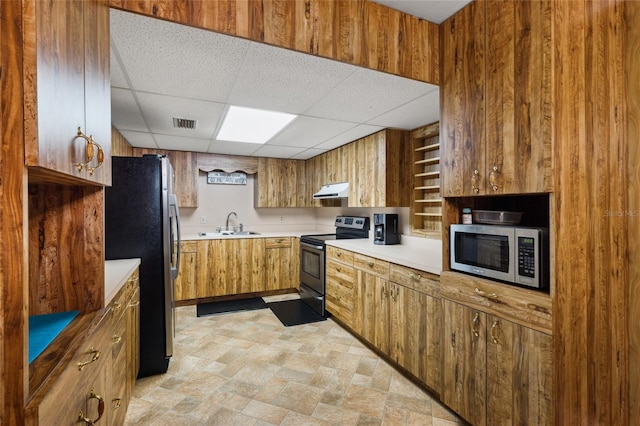 kitchen with light tile patterned floors, appliances with stainless steel finishes, a drop ceiling, and sink