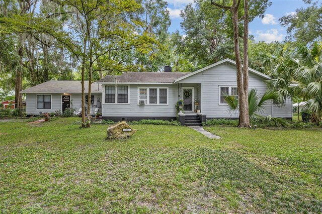 ranch-style house with cooling unit and a front yard