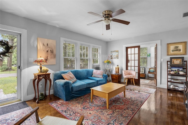 living room featuring plenty of natural light, ceiling fan, and dark wood-type flooring