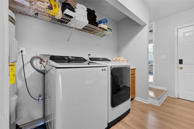 laundry area with separate washer and dryer and light wood-type flooring