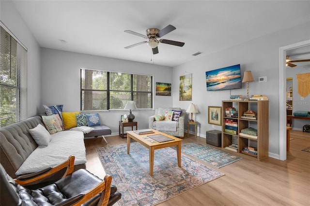 living room with light wood-type flooring and ceiling fan