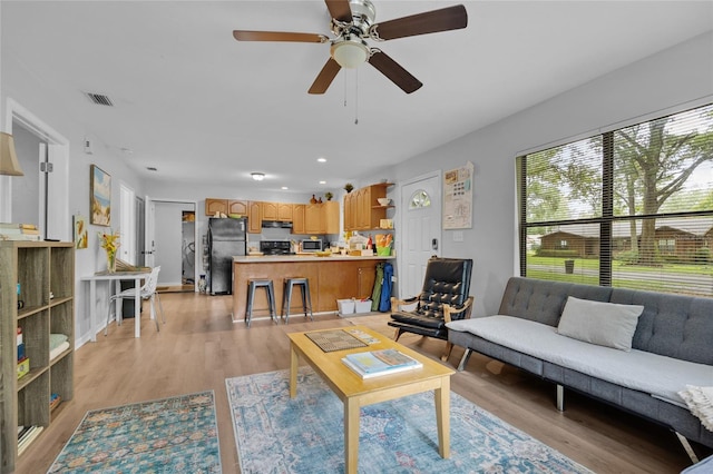 living room featuring light hardwood / wood-style flooring and ceiling fan