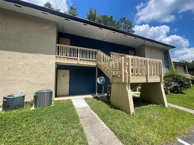 exterior space with a deck, central AC, and a yard