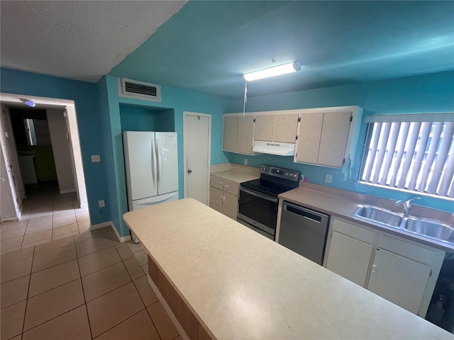 kitchen with stainless steel dishwasher, sink, range with electric cooktop, tile patterned floors, and white fridge