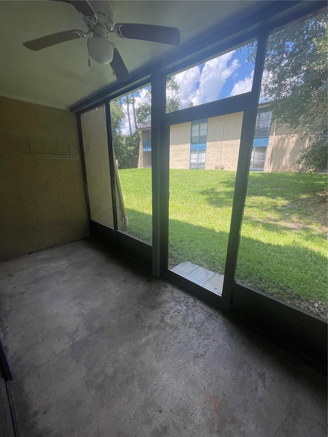 unfurnished sunroom featuring ceiling fan