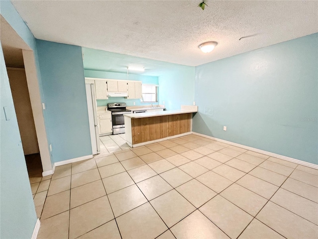 kitchen with light tile patterned flooring, a textured ceiling, white refrigerator, kitchen peninsula, and stainless steel electric stove