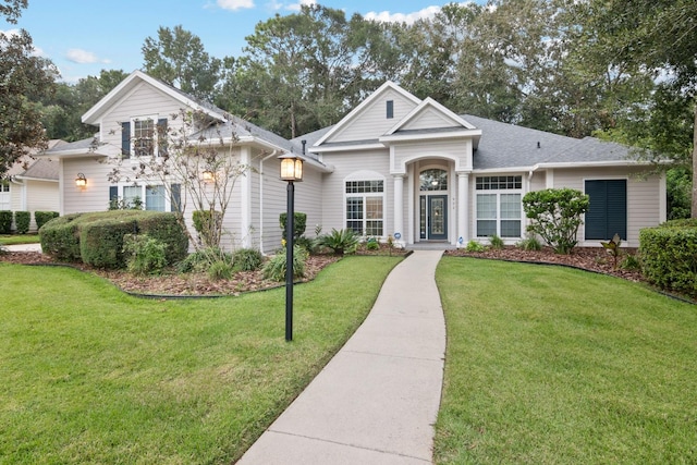 view of front of home featuring a front lawn and roof with shingles