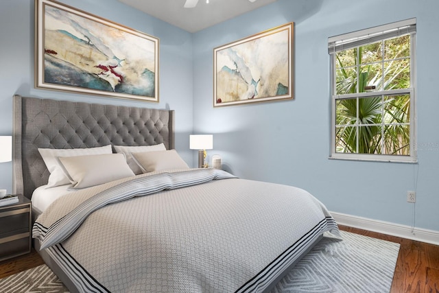 bedroom with dark hardwood / wood-style flooring and ceiling fan