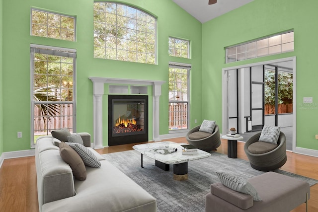 living area with light wood-type flooring and high vaulted ceiling