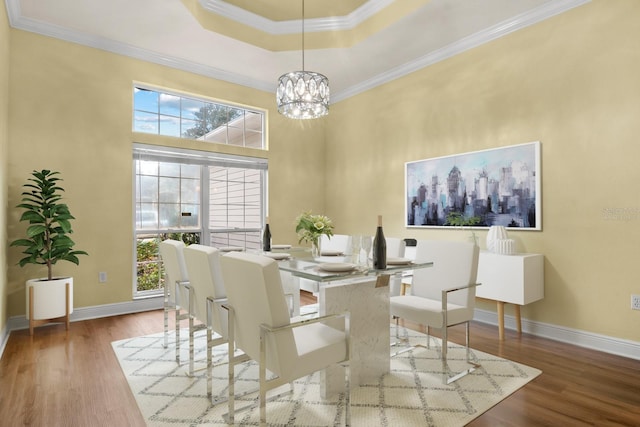 dining area featuring ornamental molding, a wealth of natural light, wood-type flooring, and an inviting chandelier