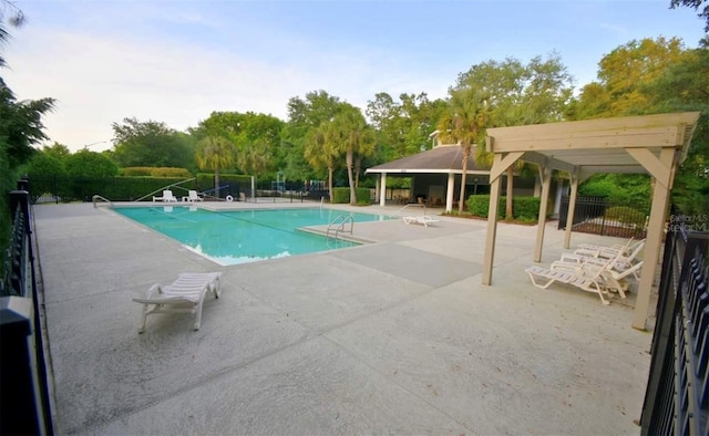 pool featuring fence, a pergola, and a patio