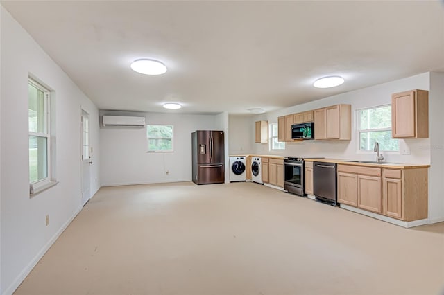 kitchen with washing machine and dryer, sink, appliances with stainless steel finishes, light brown cabinetry, and a wall unit AC