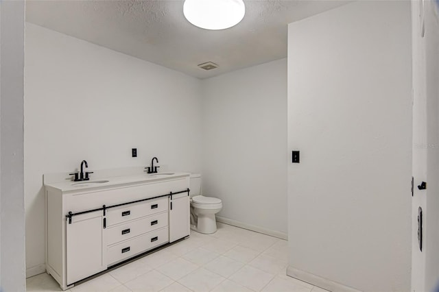 bathroom with toilet, tile patterned floors, and vanity