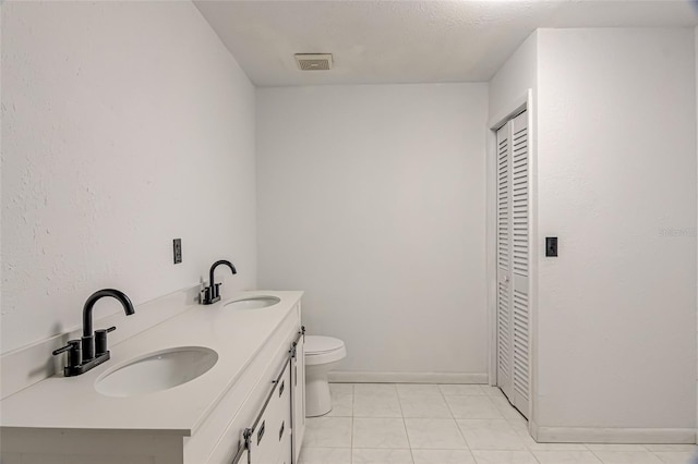 bathroom with tile patterned flooring, vanity, and toilet