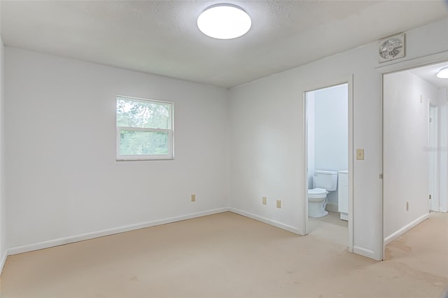 unfurnished bedroom with connected bathroom and a textured ceiling