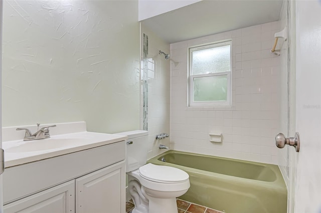 full bathroom featuring tile patterned floors, tiled shower / bath, vanity, and toilet