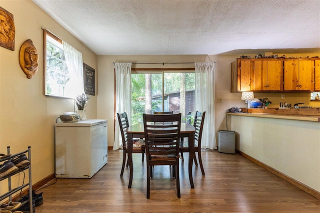 dining space featuring hardwood / wood-style floors and a textured ceiling