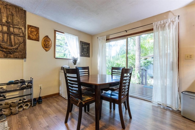 dining space with a textured ceiling and wood-type flooring