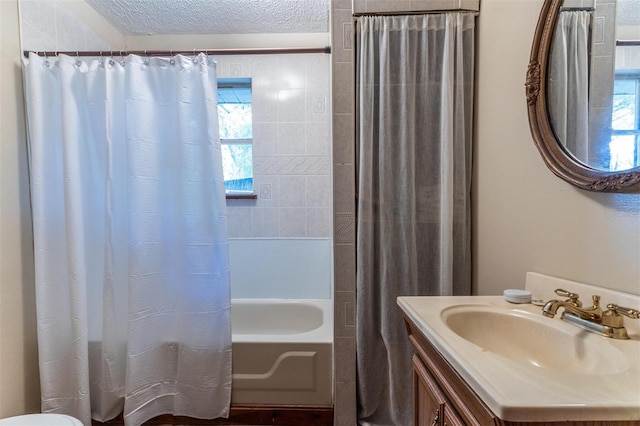 bathroom featuring a textured ceiling, shower / tub combo with curtain, and vanity