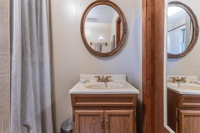 bathroom with a textured ceiling and vanity