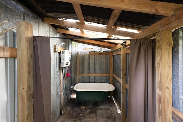 interior space featuring a tub to relax in and lofted ceiling with beams