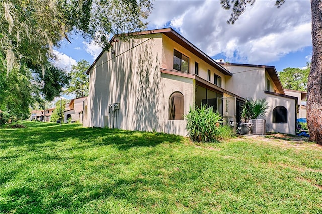 exterior space featuring central air condition unit and a front lawn