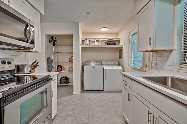 laundry area with sink and washing machine and clothes dryer