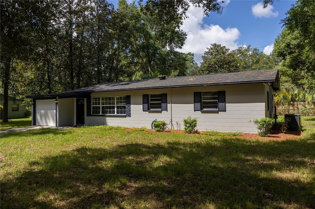 view of front of house with a garage, a front yard, and central AC