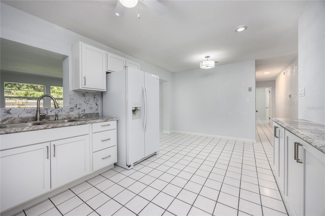 kitchen with white refrigerator with ice dispenser, white cabinetry, sink, decorative backsplash, and ceiling fan