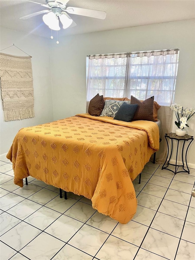 bedroom with ceiling fan, multiple windows, and light tile patterned flooring