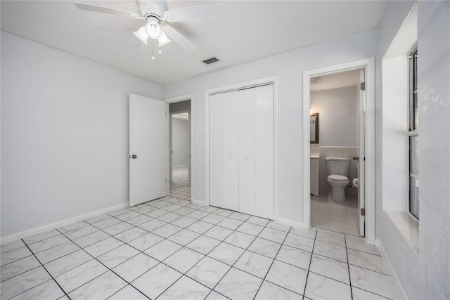 unfurnished bedroom featuring ceiling fan, visible vents, a closet, and ensuite bathroom