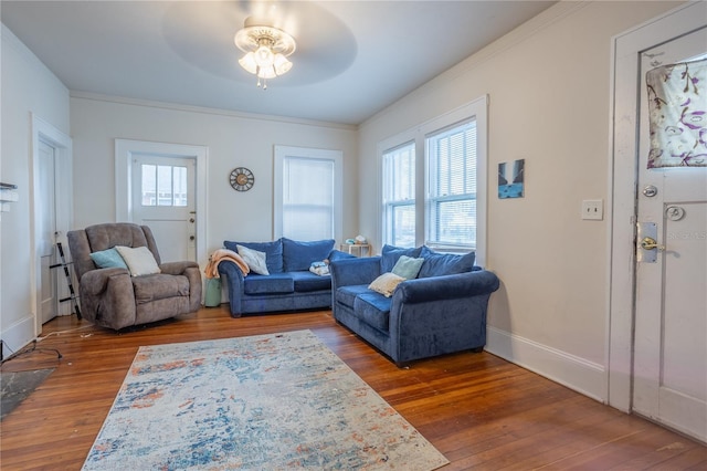 living room featuring dark wood-style floors, ornamental molding, baseboards, and ceiling fan